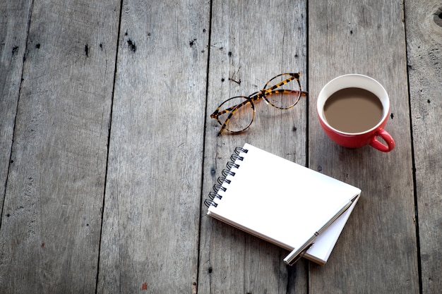 Kopieren Sie Platz von leeren Notebook und roten Tasse Kaffee auf Holzuntergrund