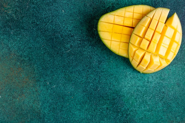 Kopierraum geschnittene Mango auf einem grünen Tisch anzeigen