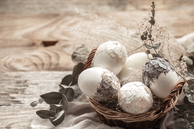 Kostenloses Foto korb mit eiern und getrockneten blumen. eine originelle idee zum dekorieren von ostereiern.