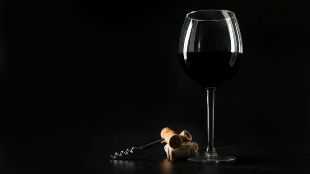 Korken und Korkenzieher nahe Glas Wein
