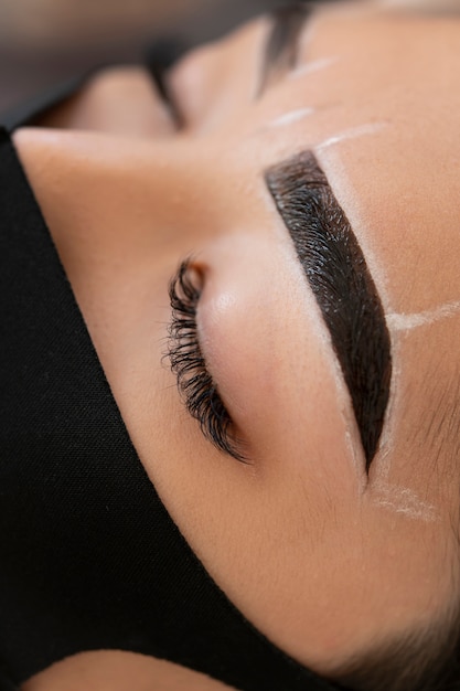 Kostenloses Foto kosmetikerin führt eine microblading-behandlung an den augenbrauen einer kundin durch