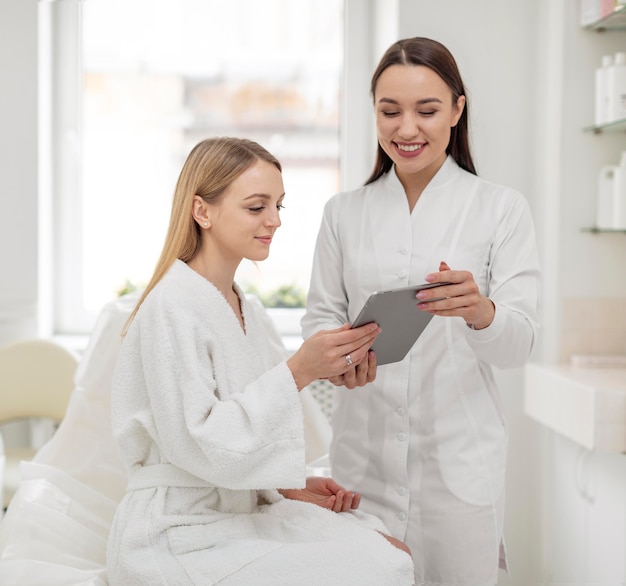 Kostenloses Foto kosmetikerin in der klinik konsultiert klient