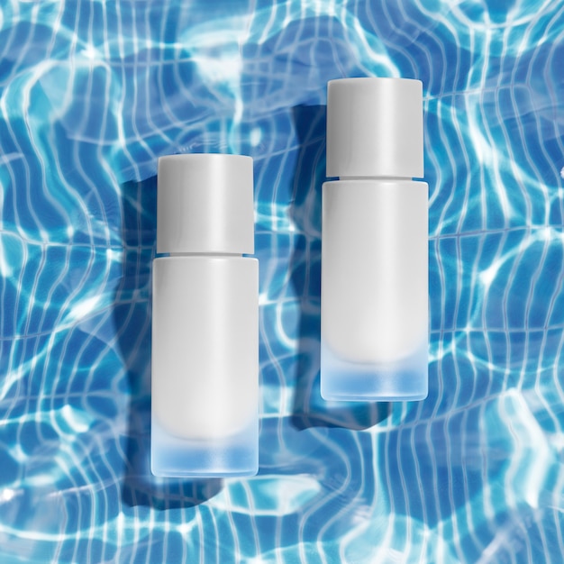 Kosmetische Flaschen auf transparentem Wasser- und Lichtreflexionshintergrund