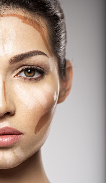 Kosmetische Make-up tonale Grundlage ist auf dem Gesicht der Frau. Schönheitsbehandlungskonzept. Mädchen macht Make-up.