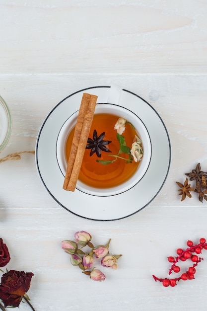 Kräutertee und Rosen mit Rosenknospen, Kräutern und Gewürzen auf weißer Oberfläche