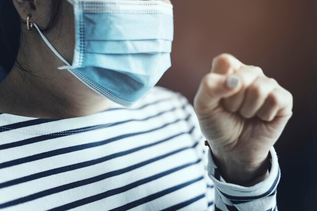 Kranke Frau, die eine Gesichtsmaske trägt, um die Ausbreitung des Coronavirus zu stoppen