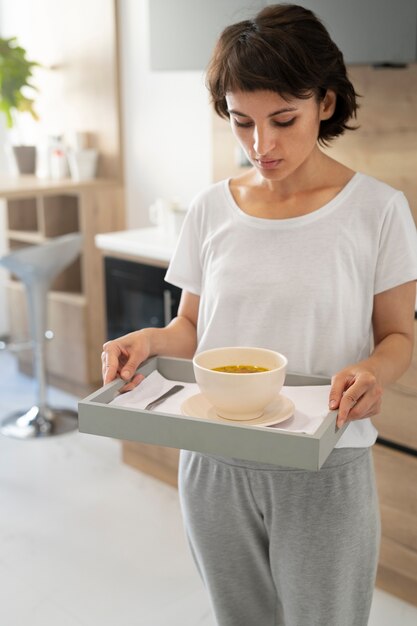 Kranke Frau mit mittlerem Schuss, die Tablett hält