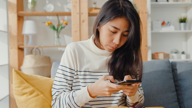 Kranke junge asiatische Frau, die Medizin hält und Foto macht, um zum Arzt geschickt zu werden