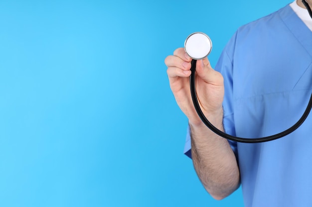 Krankenpfleger in maske mit stethoskop auf blauem hintergrund