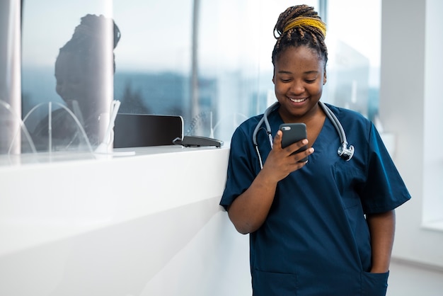 Krankenschwester der Vorderansicht, die Smartphone hält
