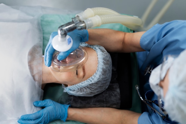 Krankenschwester, die dem Patienten eine Sauerstoffmaske aufsetzt
