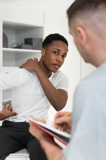 Krankenschwester, die sich Notizen über die Schmerzen des Patienten macht