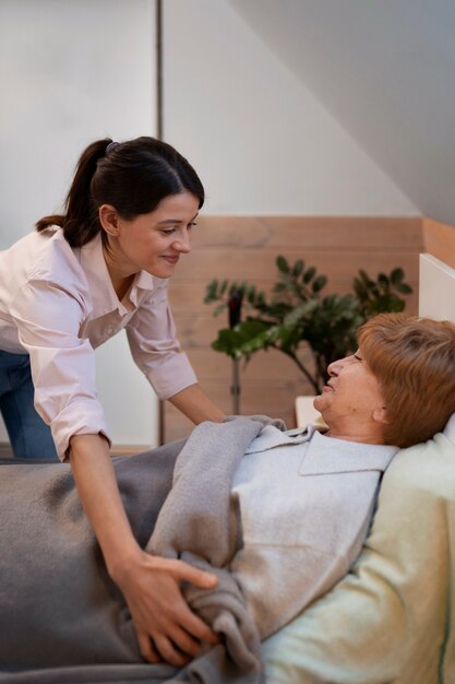 Krankenschwester, die sich um ältere Menschen kümmert