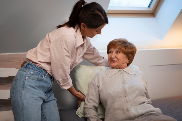 Kostenloses Foto krankenschwester, die sich um ältere menschen kümmert