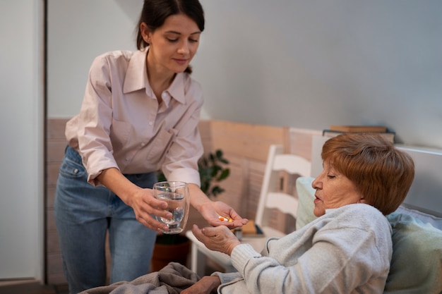 Krankenschwester, die sich um ältere Menschen kümmert