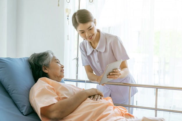 Krankenschwester Informieren Sie die Ergebnisse der Gesundheitsuntersuchung, um ältere ältere Patientinnen im krankenhausmedizinischen Seniorenkonzept zu ermutigen
