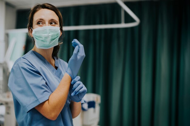 Krankenschwester mit Maske Handschuhe anziehen