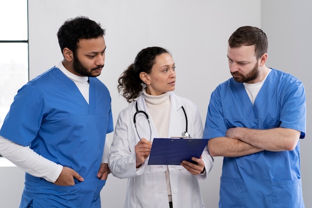 Krankenschwestern diskutieren mit Arzt Halbtotale
