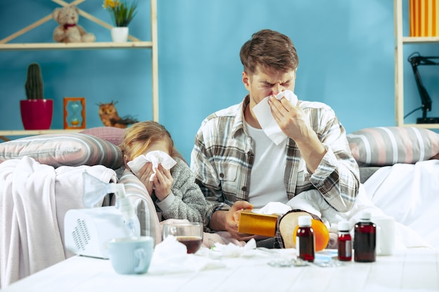 Kranker Mann mit Tochter zu Hause. Behandlung zu Hause. Mit einer Krankheit kämpfen. Medizinische Gesundheitsversorgung.