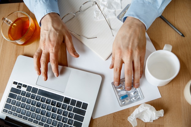 Kranker Mann während der Arbeit im Büro