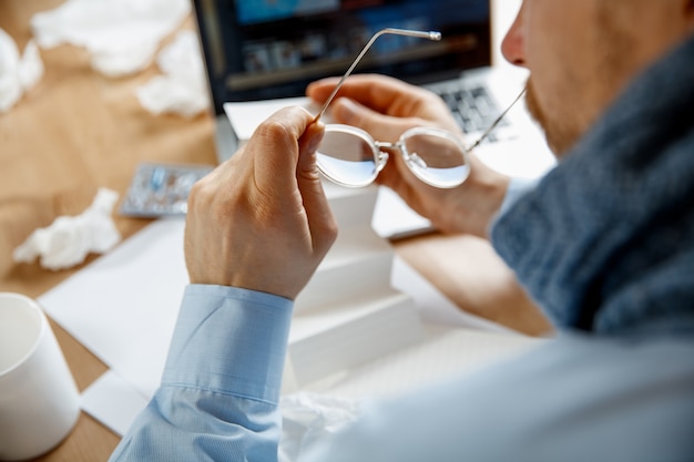 Kranker Mann während der Arbeit im Büro