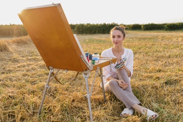 Kreative junge Frau, die in der Natur sitzt