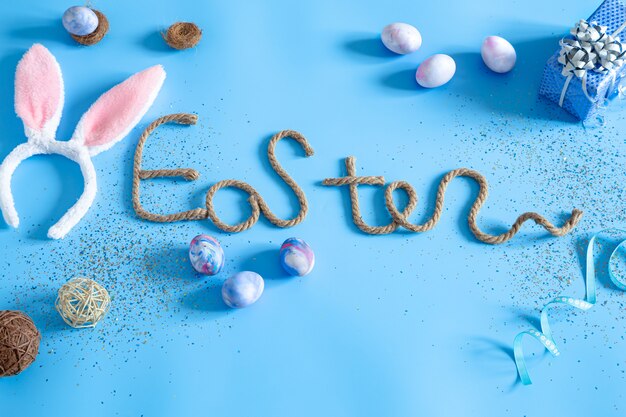 Kreative Osterinschrift auf Blau mit Gegenständen des Osterdekors.