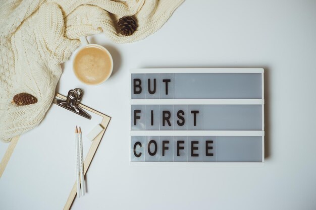 Kreativer Schreibtisch Aber erster Kaffee-Arbeitsbereich mit Klemmbrett-Stiftbecher auf weißem Hintergrund Flache Ansicht von oben