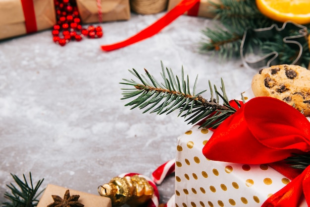 Kreis aus Orangen, Keksen, Tannenzweigen, roten Geschenkkartons und anderen Arten von Weihnachtsdekor