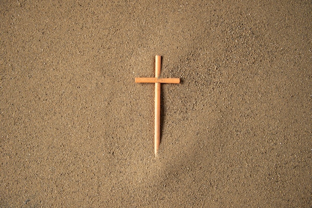 Kreuz auf den Sand kleben