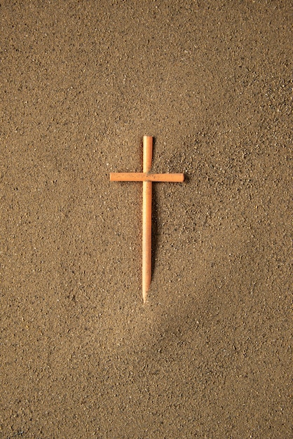 Kreuz auf den Sand kleben