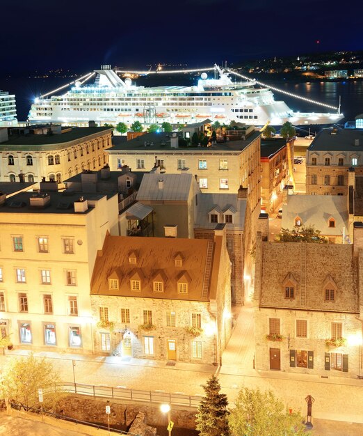 Kreuzfahrtschiff und alte Gebäude der Unterstadt in Quebec City bei Nacht.