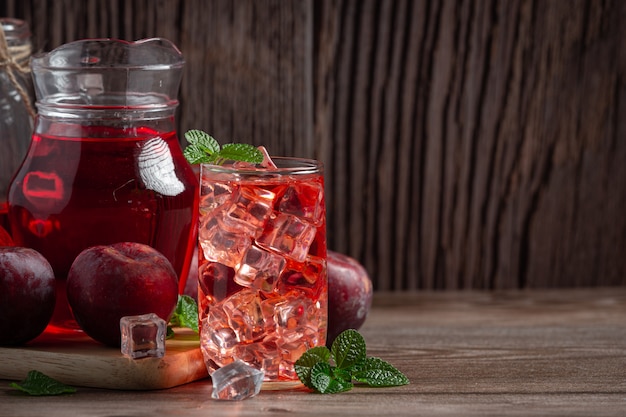 Kostenloses Foto krug und ein glas pflaume auf holzboden gestellt