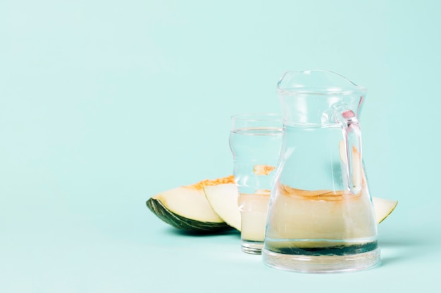 Kostenloses Foto krug und glas wasser mit melonenscheiben