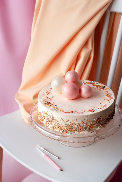 Kostenloses Foto kuchen für geburtstagsfeier auf stuhl mit luftballons