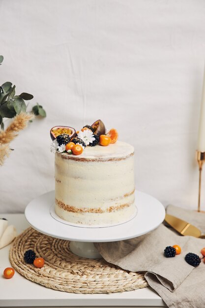 Kuchen mit Beeren und Passionsfrüchten neben einer Pflanze hinter einem Weiß