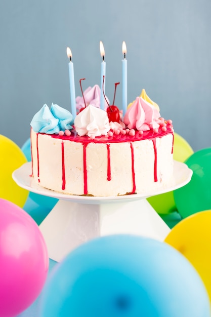 Kuchen mit Kerzen und Luftballons