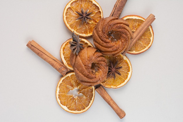 Kuchen mit Orangenscheiben und Zimt auf weißer Oberfläche