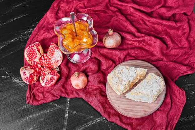 Kuchenscheiben und Confiture auf rotem Handtuch