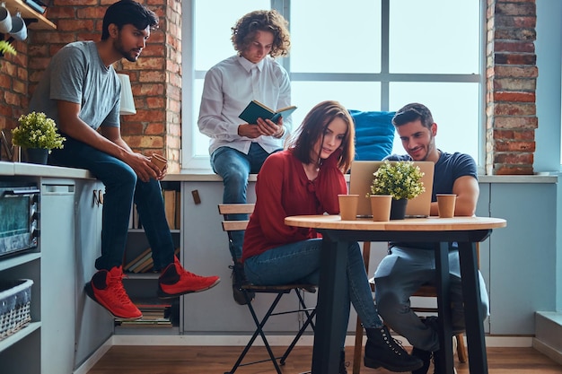 Küche im Studentenwohnheim. Gruppe gemischtrassiger Studenten, die sich mit Bildung beschäftigen.