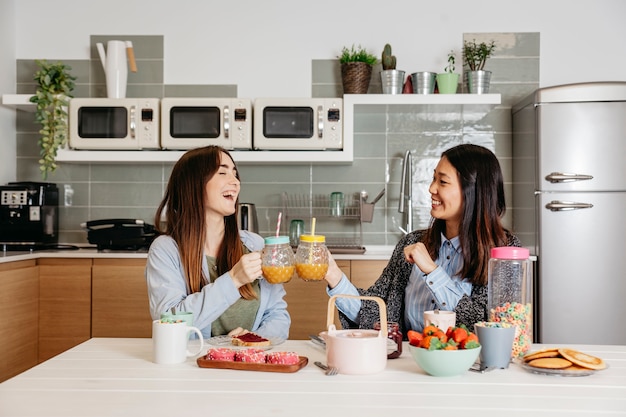 Kühlende girlfiends, die Getränke am Frühstück genießen