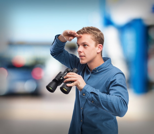 kühler junger Mann mit dem Fernglas