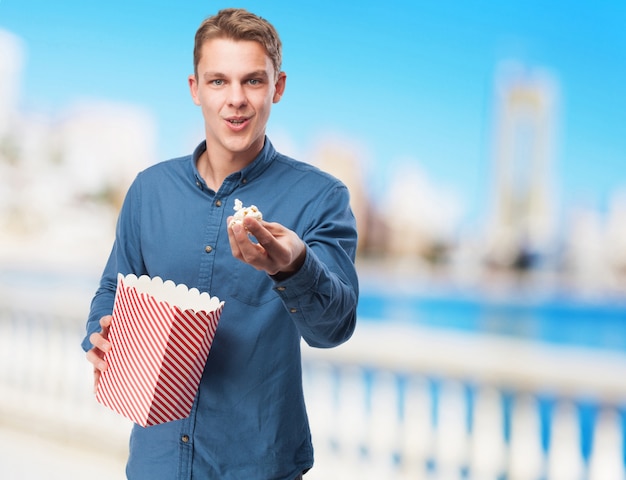 kühler junger Mann mit Popcorn