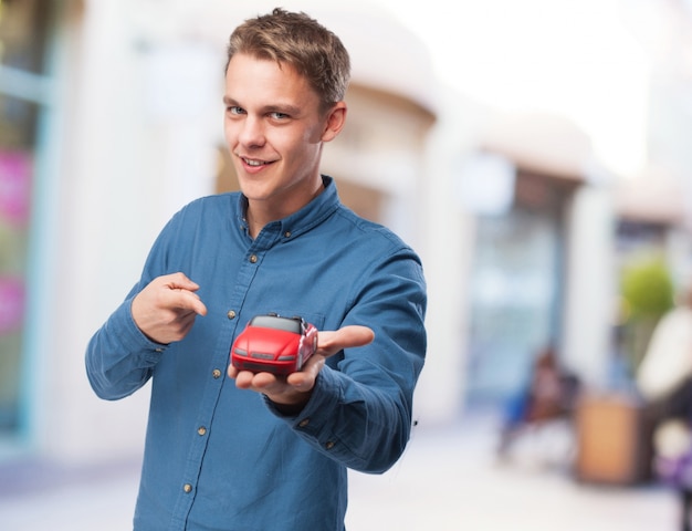 kühler junger Mann mit rotem Auto