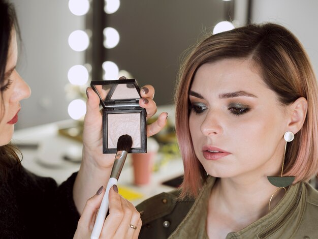 Künstler, der Pinsel im Make-up eintaucht