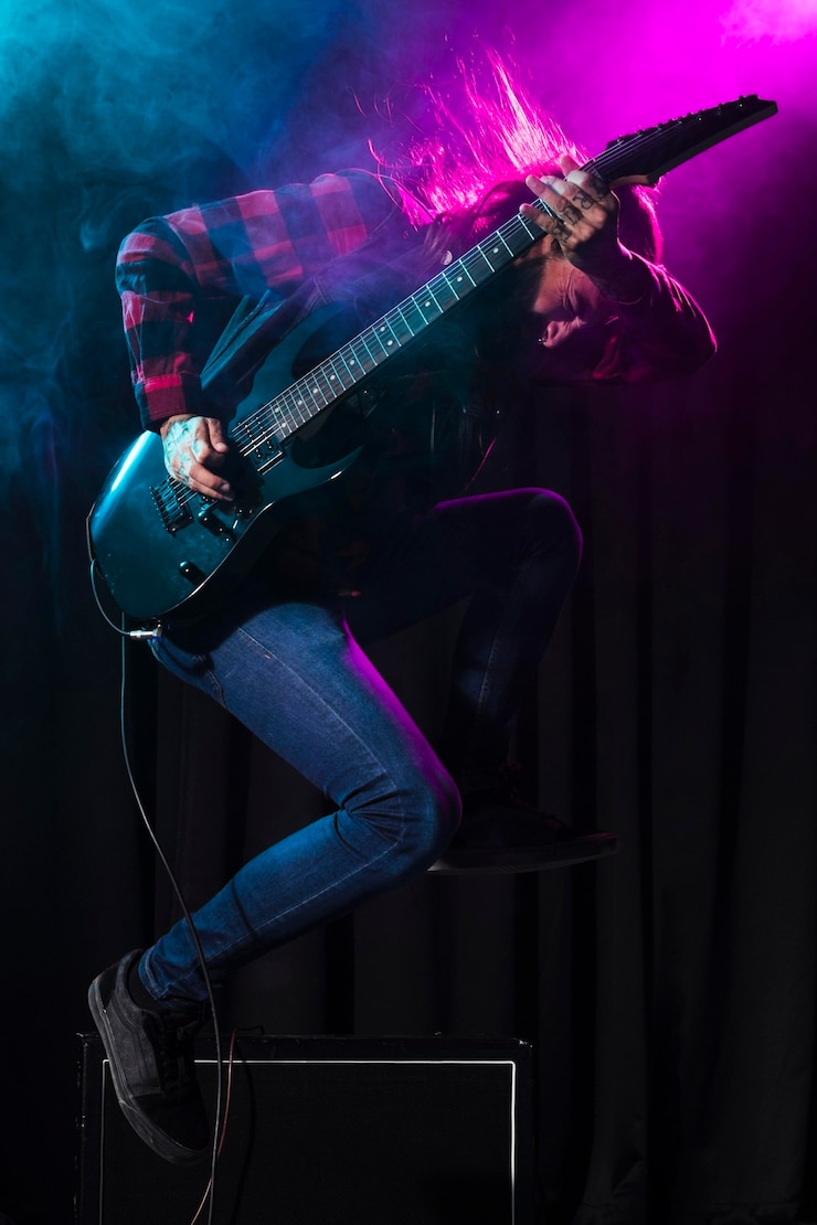 Kostenlose Foto künstler spielt gitarre und springt seitwärts