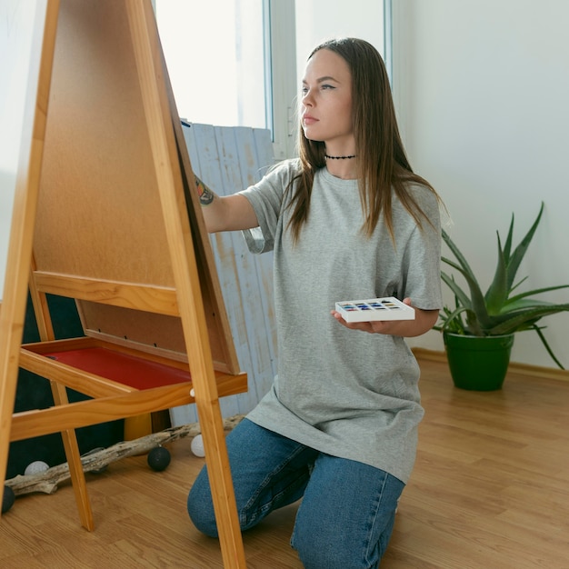 Kostenloses Foto künstlerfrau malt auf leinwand seitenansicht