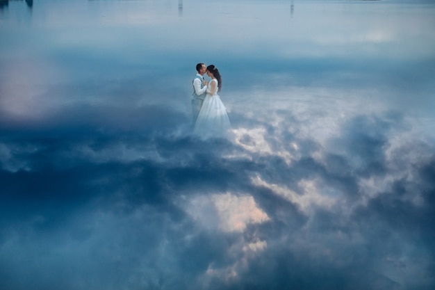Künstlerisches Foto des eleganten, sanften, stilvollen Bräutigams und der Braut, die Hochzeitstanz tanzen, während der Mann hübsche Dame küsst. Hochzeitspaar in Liebeskonzept