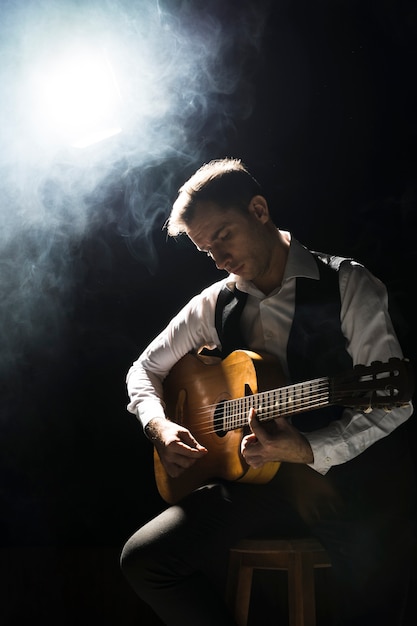 Künstlermann auf der Bühne spielt die klassische Gitarre