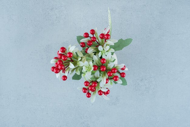 Künstliche Blumen mit Beeren auf Blau